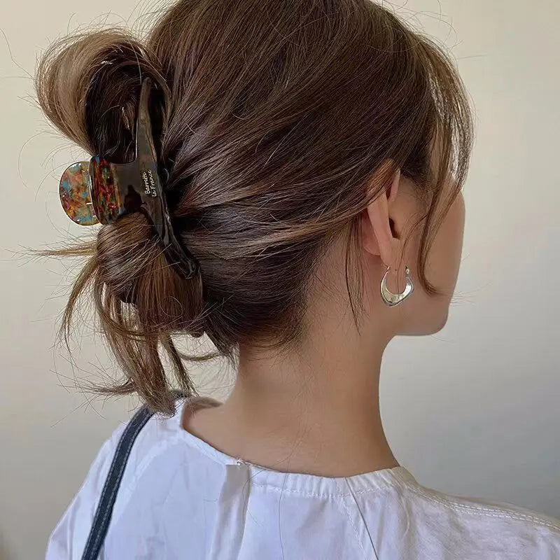 Back view of a half-up twist held by a tortoiseshell-pattern claw clip