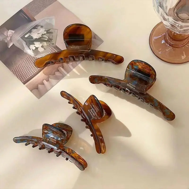Tortoiseshell-pattern claw clips in several sizes on a table; you receive one clip
