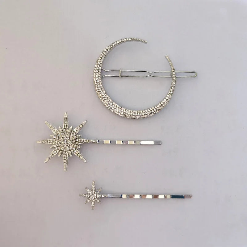 Close-up of a rhinestone moon clip and two star hair pins