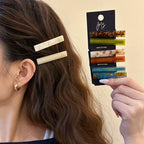 Ivory white geometric clips worn at the side of long wavy hair