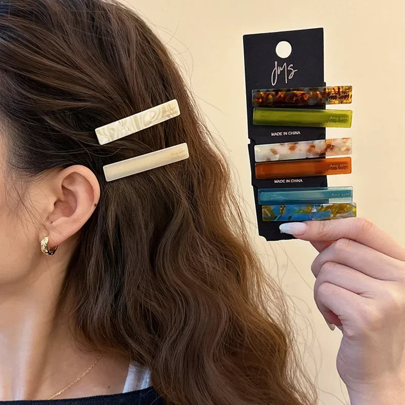 Ivory white geometric clips worn at the side of long wavy hair