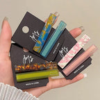 Hand holding geometric hair clip sets in blue, pink, tortoise and olive