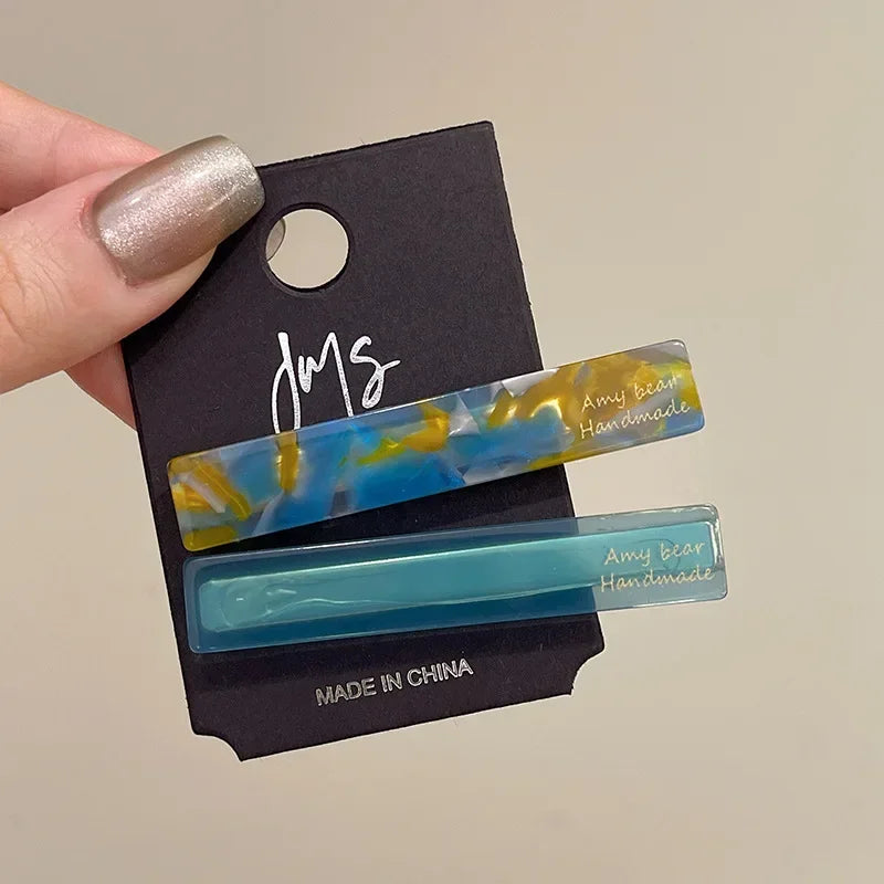 Geometric side clips in blue marble-look and teal